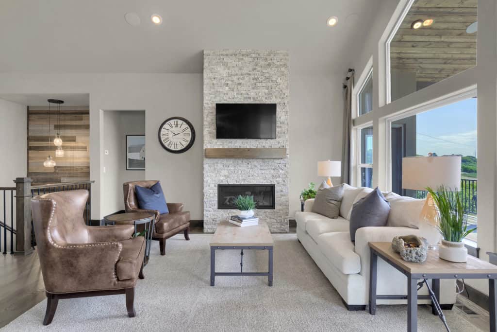 a photo of a living room with a tall stone fireplace