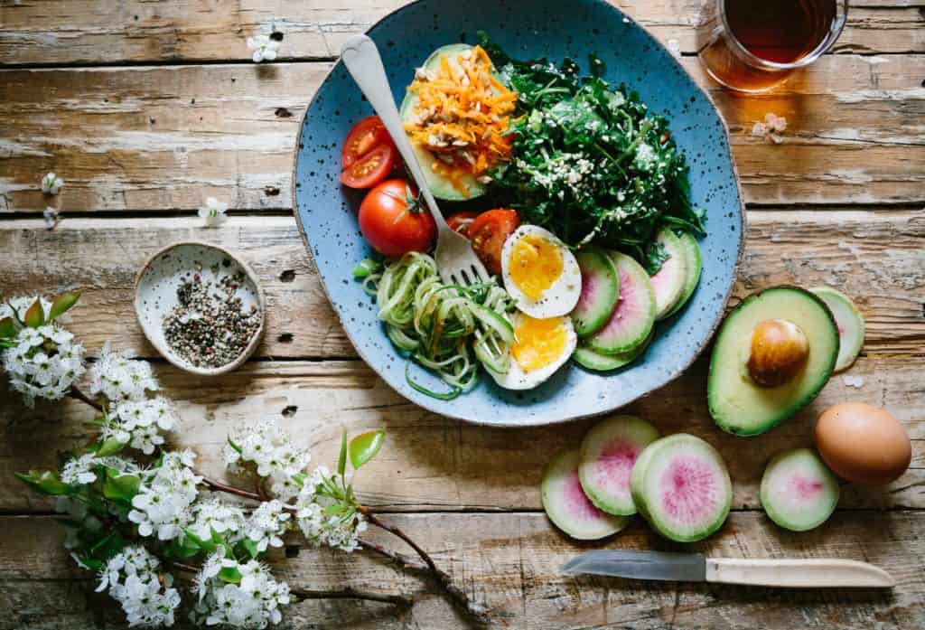 Wood table with fresh fruit and vegetables in a bowl