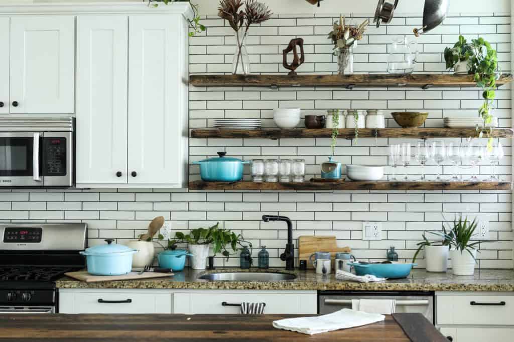 a photo of a kitchen with shelving instead of cabinets